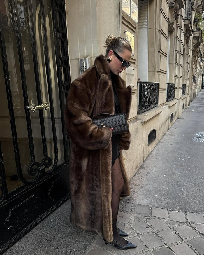 Full-length faux fur coat falling past the knee, worn open